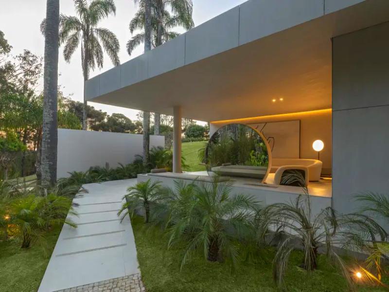 Formas orgânicas e inspiração brutalista integram living à paisagem